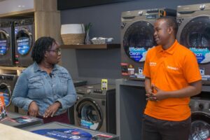 Moraa Onchwari (left), Branch Manager at Hotpoint Sarit Centre, having a chat with Allan Mwenda (right), Senior Sales Agent, Aspira.