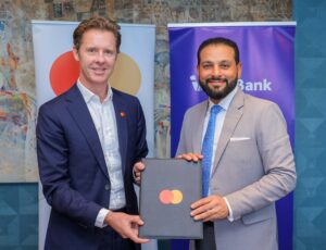 Mark Elliott, President for Africa at Mastercard (L) and Gul Khan, CEO of I&M Bank (R) holding the framework agreement which will extend their s